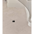 Beige sloane limestone honed finish stone tiles with subtle speckled texture in herringbone pattern with black accent tile