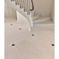 Sloane limestone honed finish floor tiles in cream color with subtle veining and black square inlays