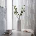 Solinda Mixed Format Mosaic silver glass mosaic with a woven ceramic vase of eucalyptus