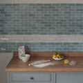 South Cliff cotton brick tile backsplash with glossy teal blue rectangular tiles arranged in a classic brick pattern