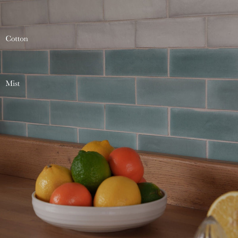 White ceramic bowl filled with citrus fruits placed on south cliff mist brick tile showcasing earthy tones and texture