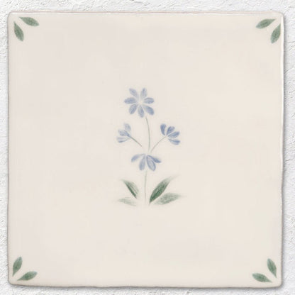 Cream-colored ceramic tile spring alice 13 x 13cm with delicate hand-painted floral design in blue and green hues