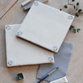 White ceramic spring april cornflower tile 13 x 13cm with delicate green and purple leaf motifs at each corner