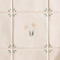 Cream-colored ceramic tile spring elsie 13 x 13cm with delicate hand-painted yellow flowers and green leaves