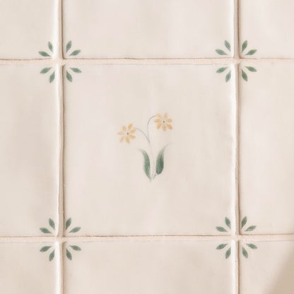 Cream-colored ceramic tile spring elsie 13 x 13cm with delicate hand-painted yellow flowers and green leaves