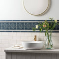 White ceramic vessel sink with gold toned faucet on ascot blue countertop from st james collection