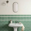 White pedestal sink st james on jade breeze with chrome faucets and beige towel draped over edge