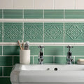 The bathroom wall features st james on jade breeze green ceramic tile with intricate floral embossing