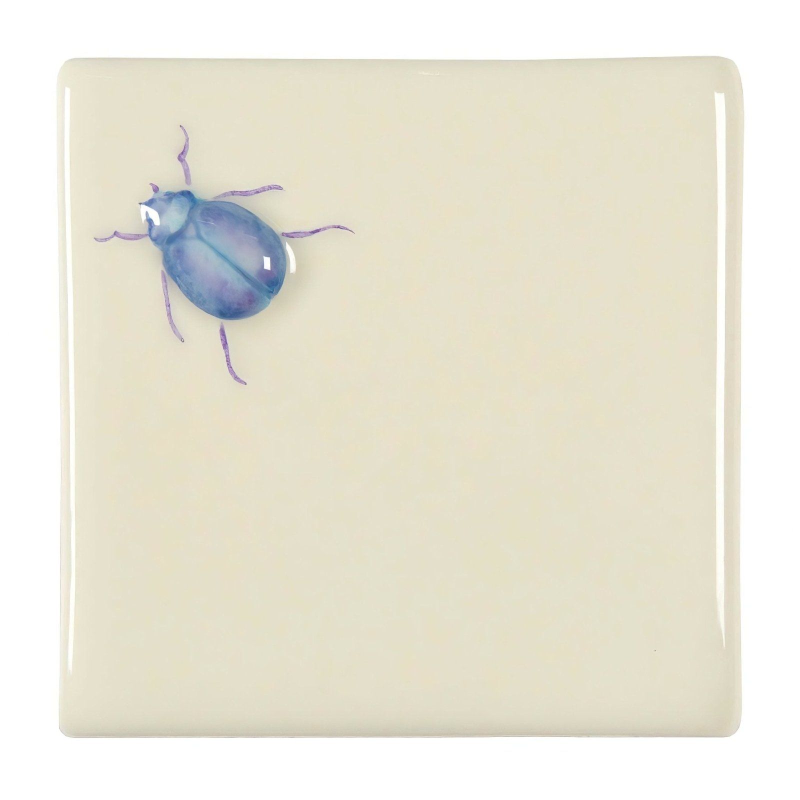 A glossy cream-colored ceramic tile featuring a delicately painted blue and purple stag beetle on off white background