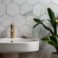 Statuario Nuovo Honed Hexagon Mosaic white marble hexagonal mosaic with a white sink and gold tap