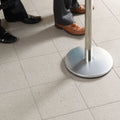 Silver metallic stanchion base with circular flat design and polished finish alongside steel grey pebbled aggregate quarry tile 300x300x11mm
