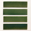 Four rectangular green ceramic tiles with matte finish showing subtle olive to deep forest shades from stone glaze ceramic british green gloss brick