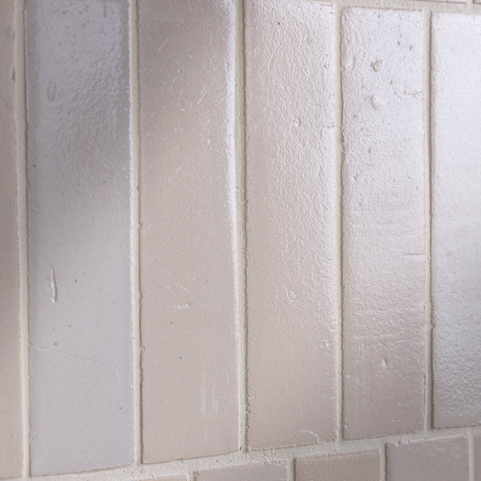 Light gray stone glaze ceramic chalkstone gloss brick tiles with textured matte finish arranged in vertical rows