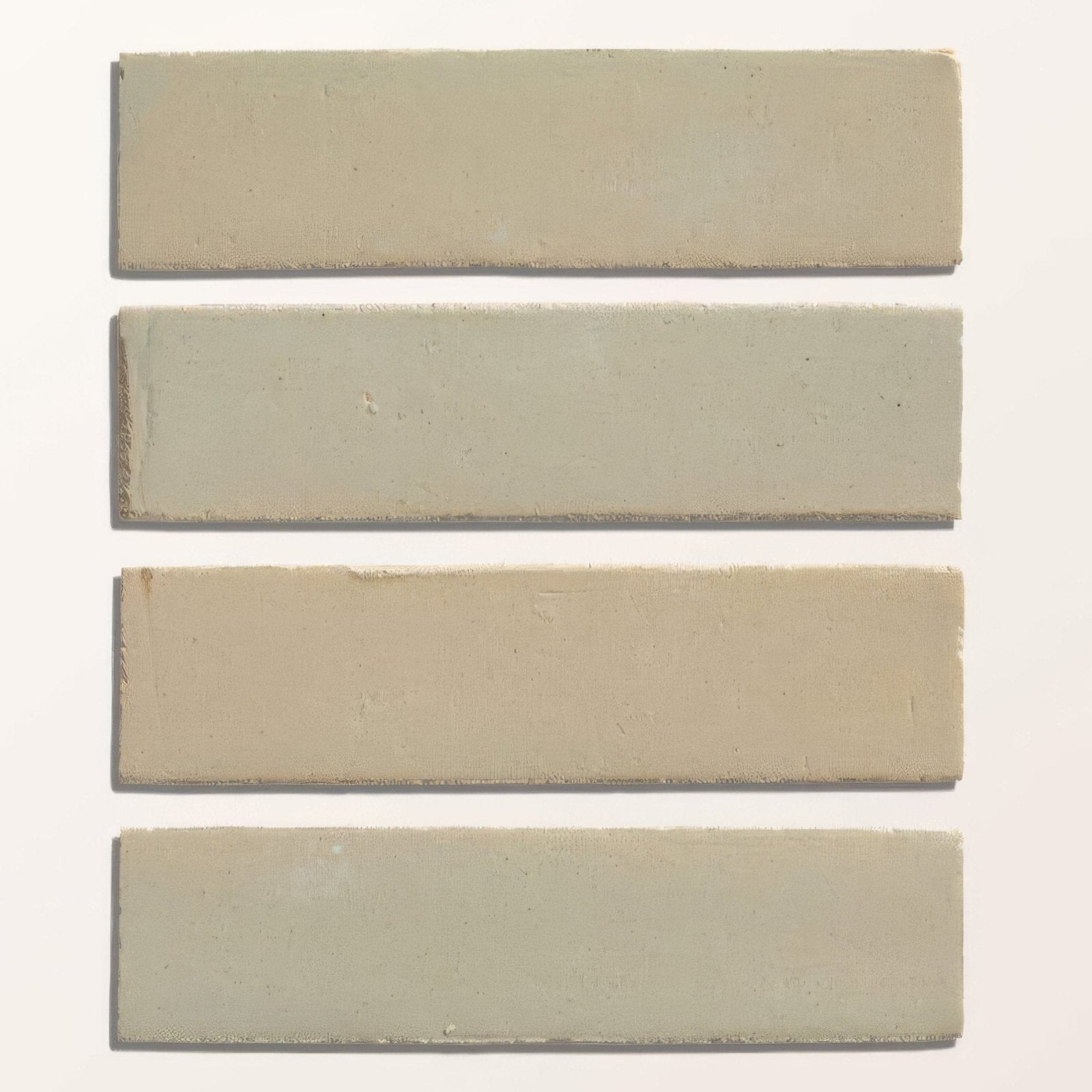 Four rectangular matte finish stone glaze ceramic chambray gloss brick tiles in muted sage green to beige tones