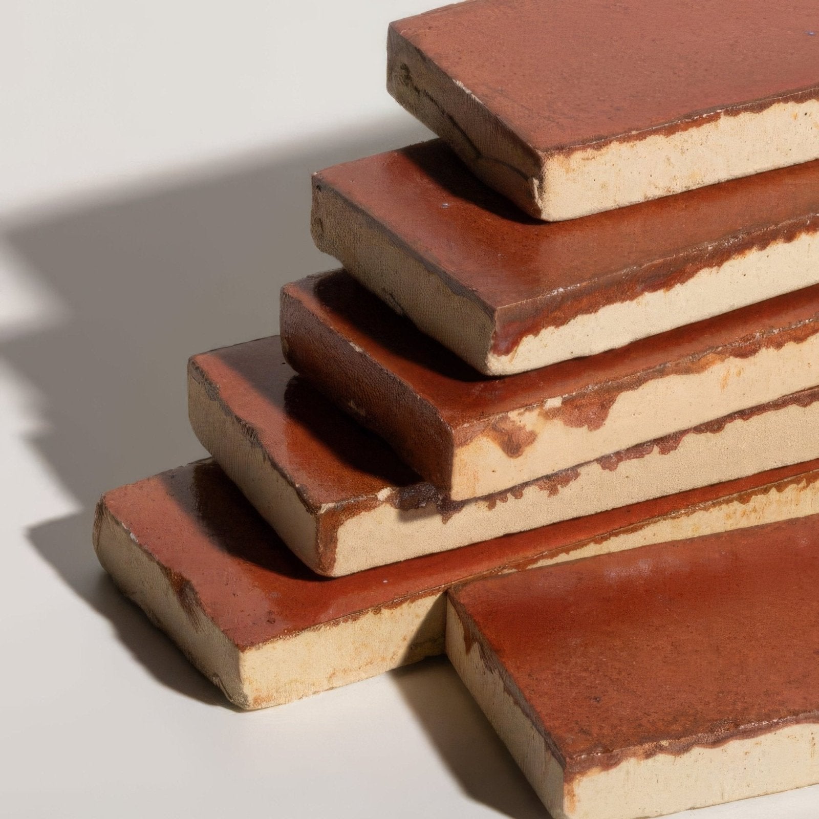 Stacked terracotta stone glaze ceramic imperial red gloss brick tiles with a rustic handcrafted finish and earthen tones