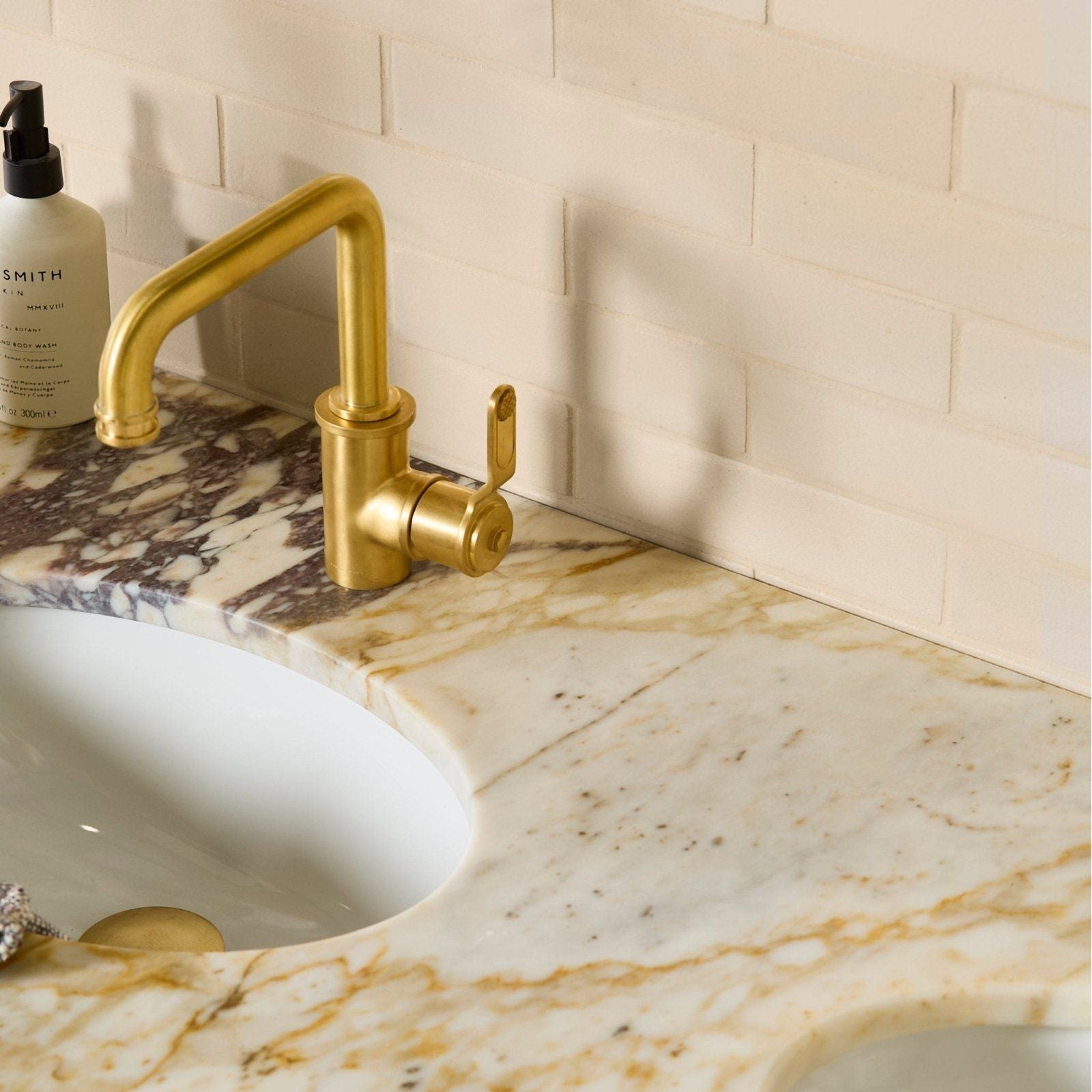 Gold-finished single-handle faucet with sleek modern design paired with stone glaze ceramic linen gloss brick