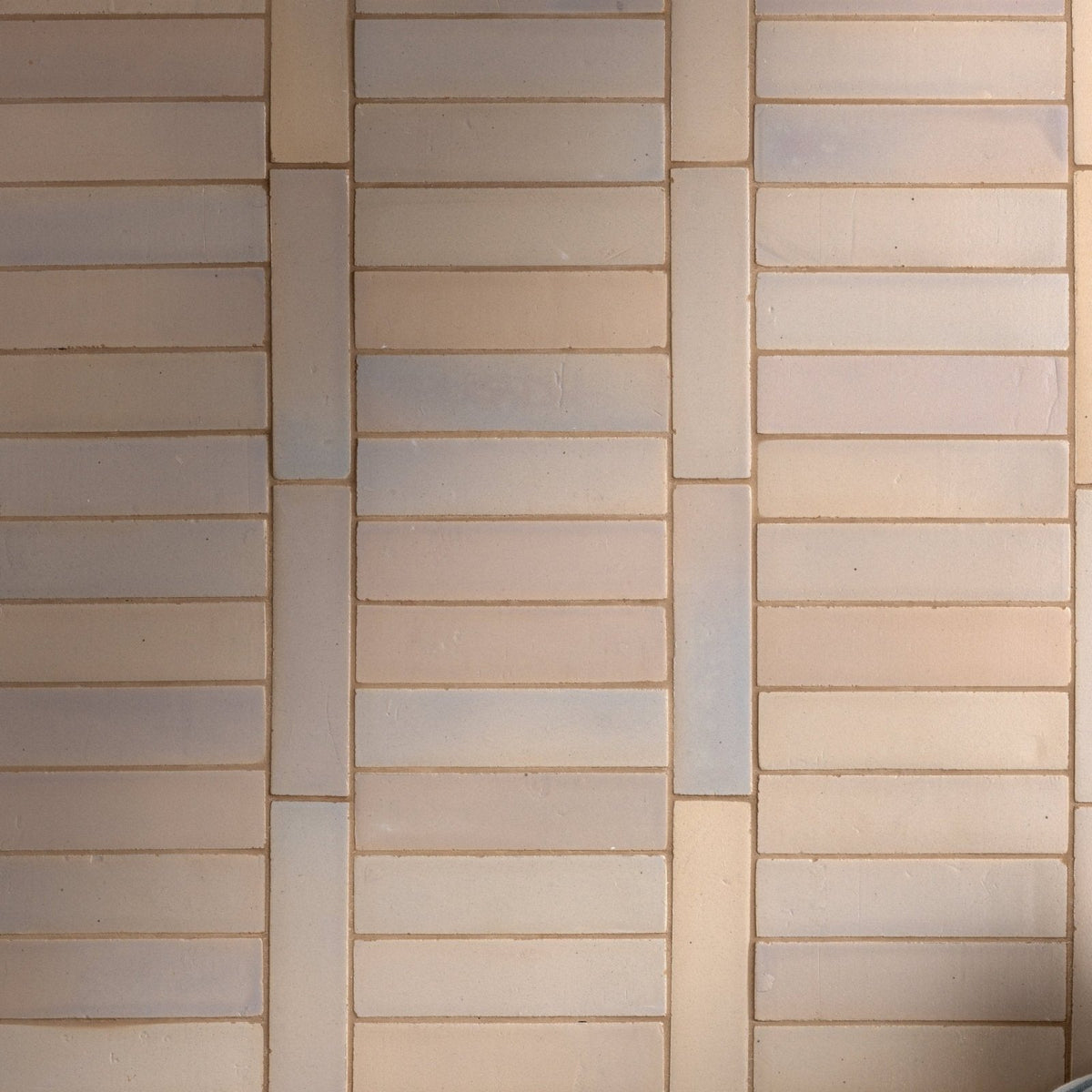 Beige and light gray stone glaze ceramic mink gloss brick tiles arranged in a staggered horizontal pattern