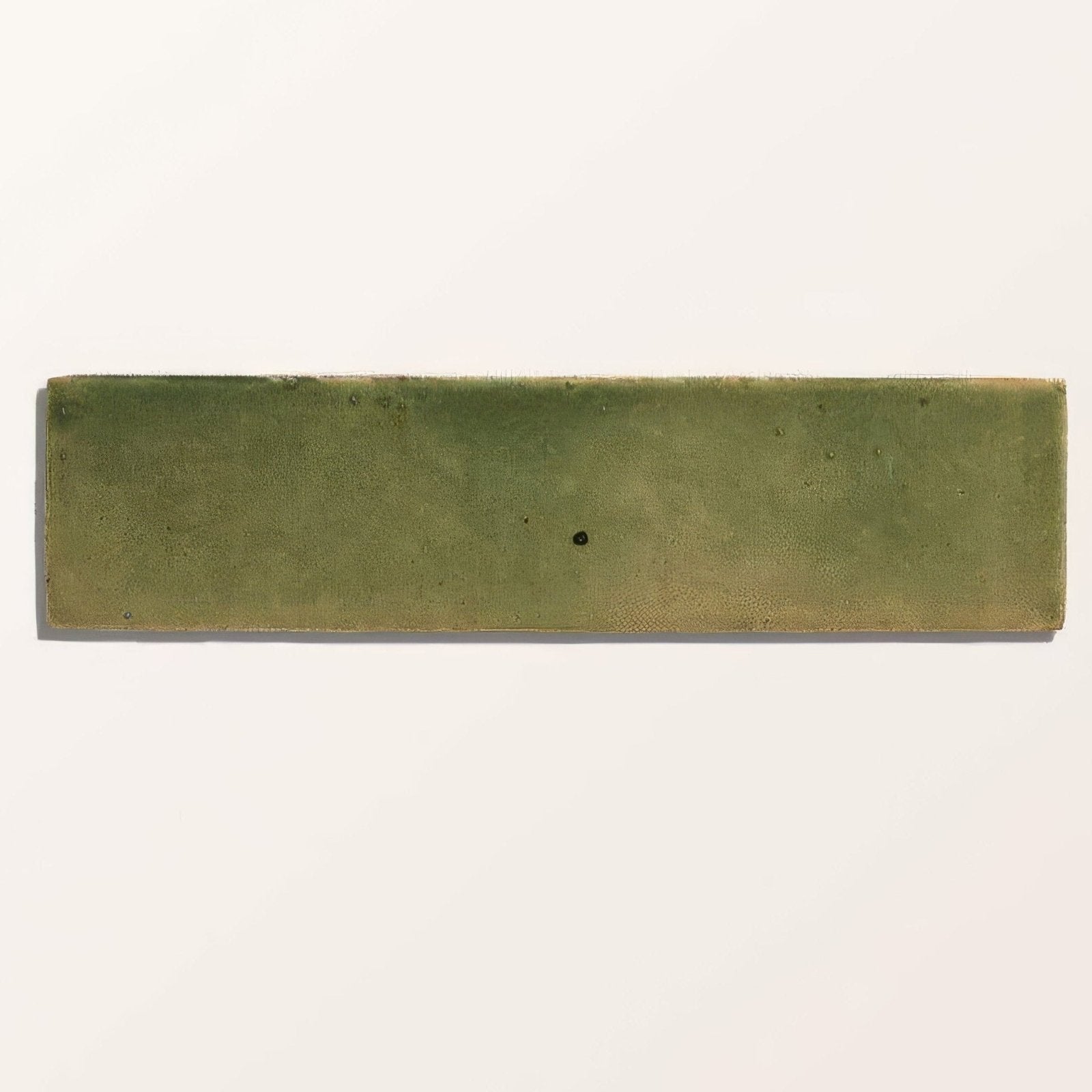 A matte olive green stone glaze ceramic tile with subtle texture and minor imperfections in a rectangular brick shape