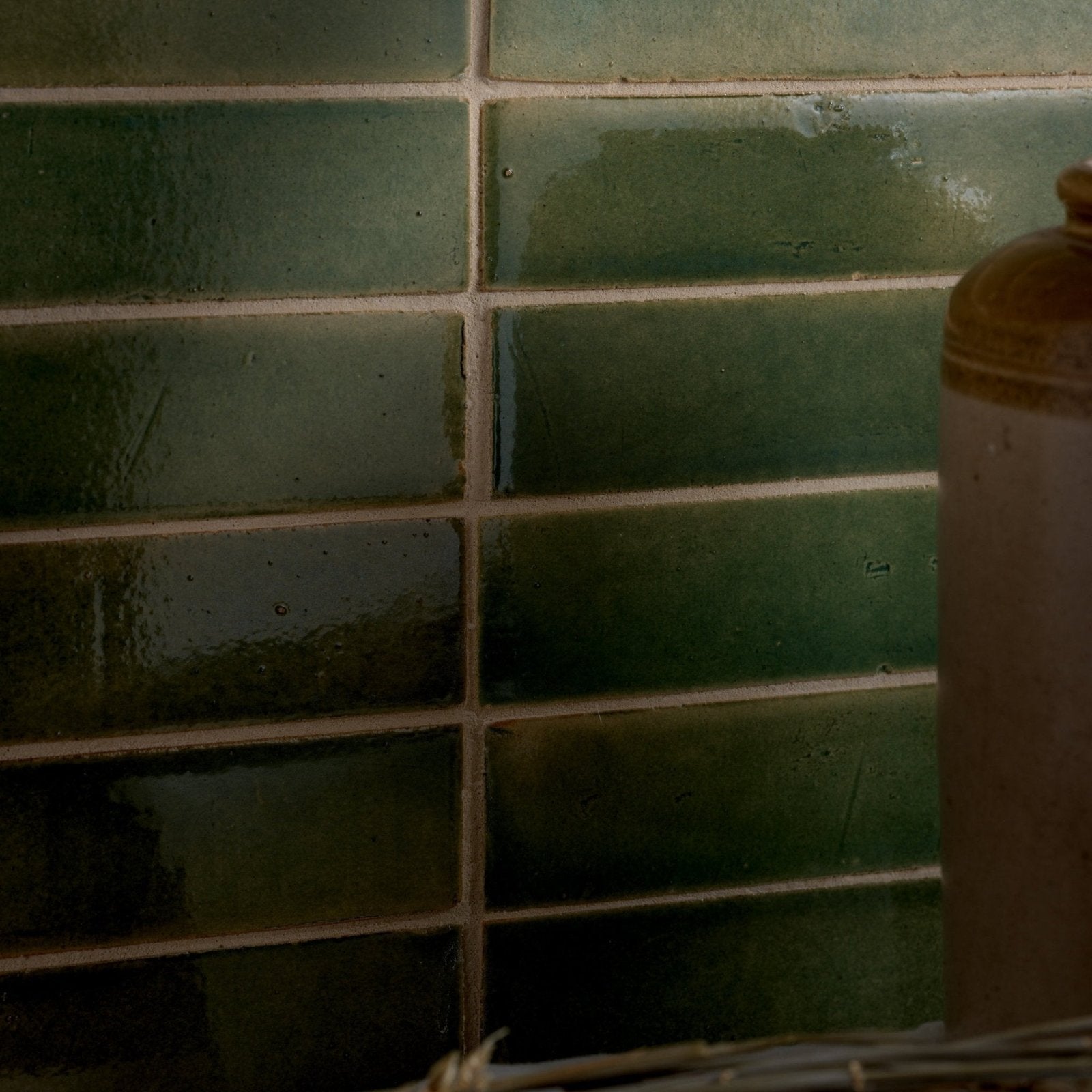 Dark green glossy ceramic tiles arranged in a horizontal brick pattern from stone glaze ceramic olive leaf gloss brick