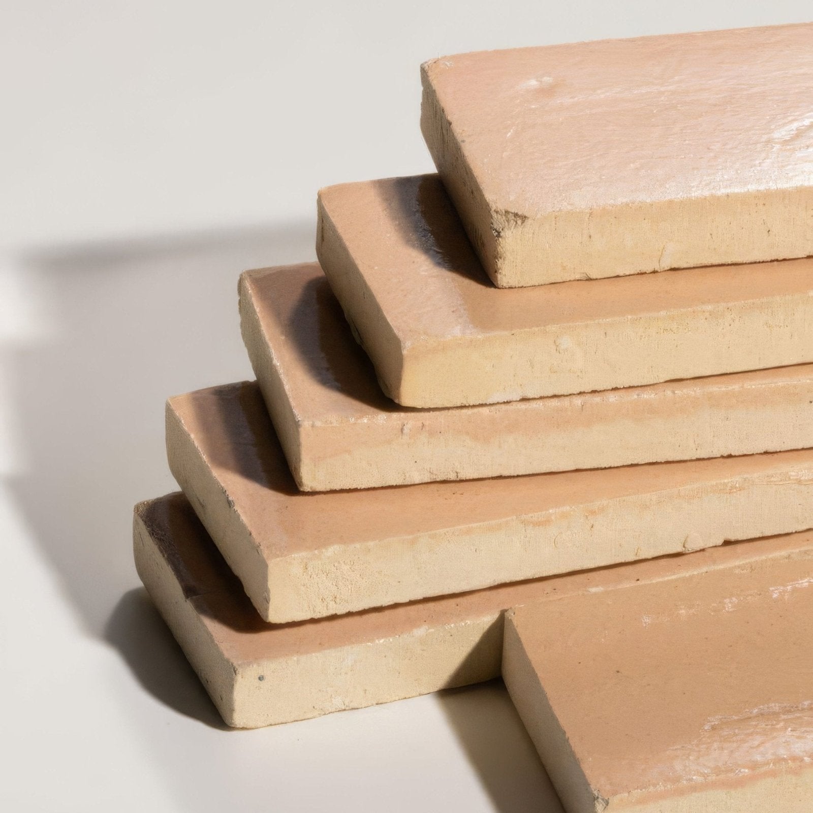 Stack of beige stone glaze ceramic petal gloss brick tiles with slightly rough matte-finished surfaces