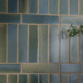 Rectangular stone glaze ceramic winter pond gloss brick tiles in muted blue and green with earth-toned grout in staggered pattern