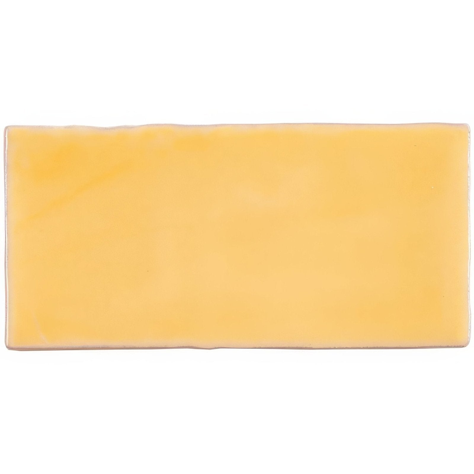 A rectangular solid yellow ceramic straw half tile wall tile with a smooth slightly glossy finish