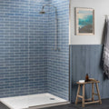 Chrome-finished stream brick tile showerhead with curved arm and circular spray head mounted on tiled wall