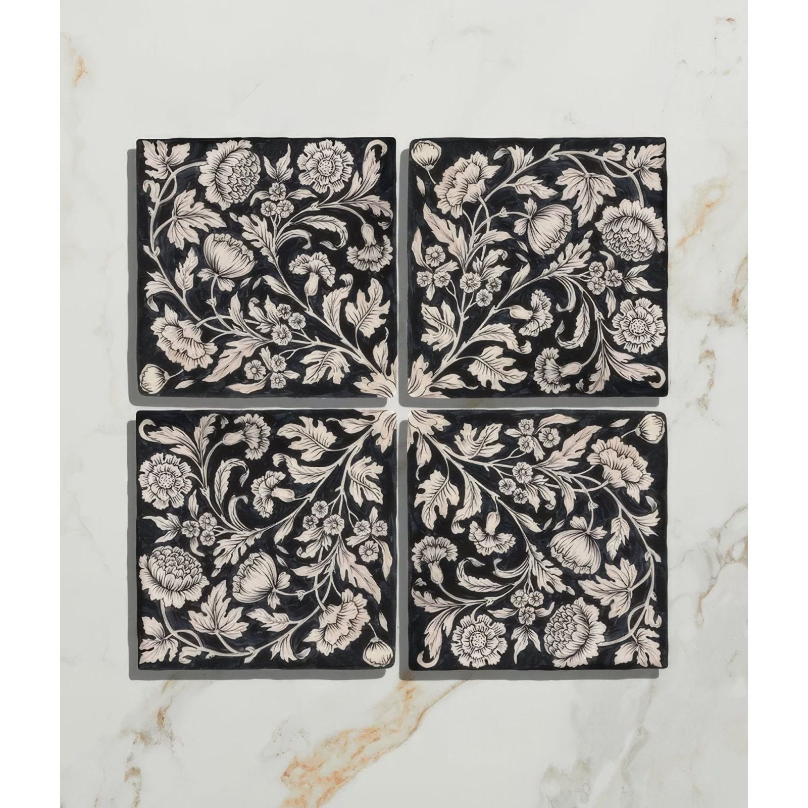 Studio assisi blue ceramic black square tiles with intricate white floral and botanical patterns in four-piece set