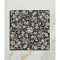 Studio assisi blue ceramic black square tiles with intricate white floral and botanical patterns in four-piece set