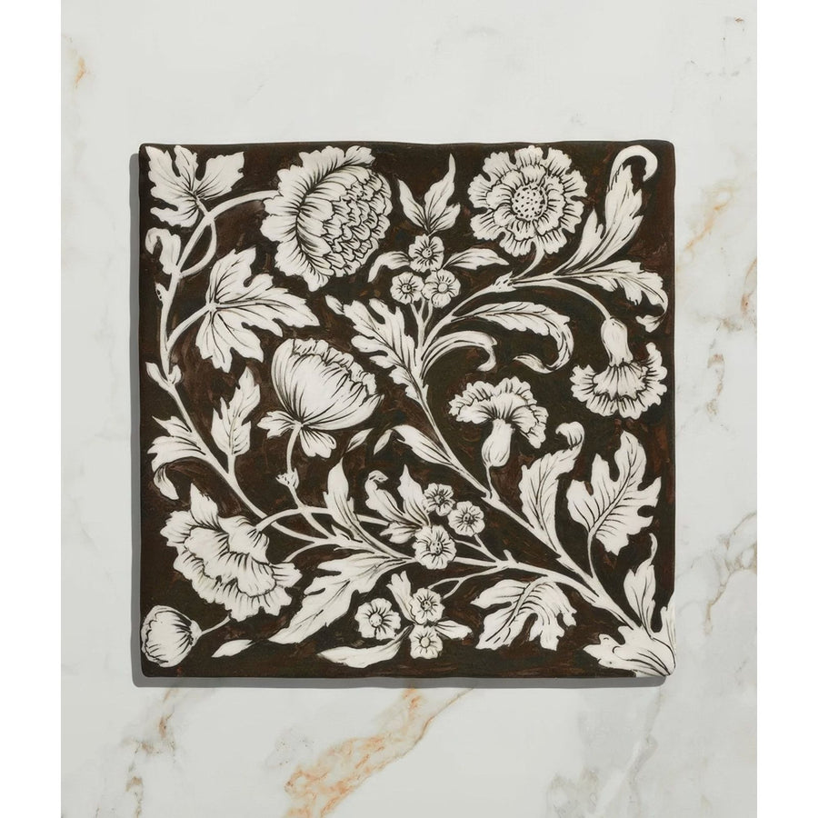 Studio Assisi Brown ceramic square tile with intricate white floral and leaf patterns on dark brown background