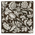 A square ceramic tile studio assisi brown with dark brown background and intricate white floral patterns