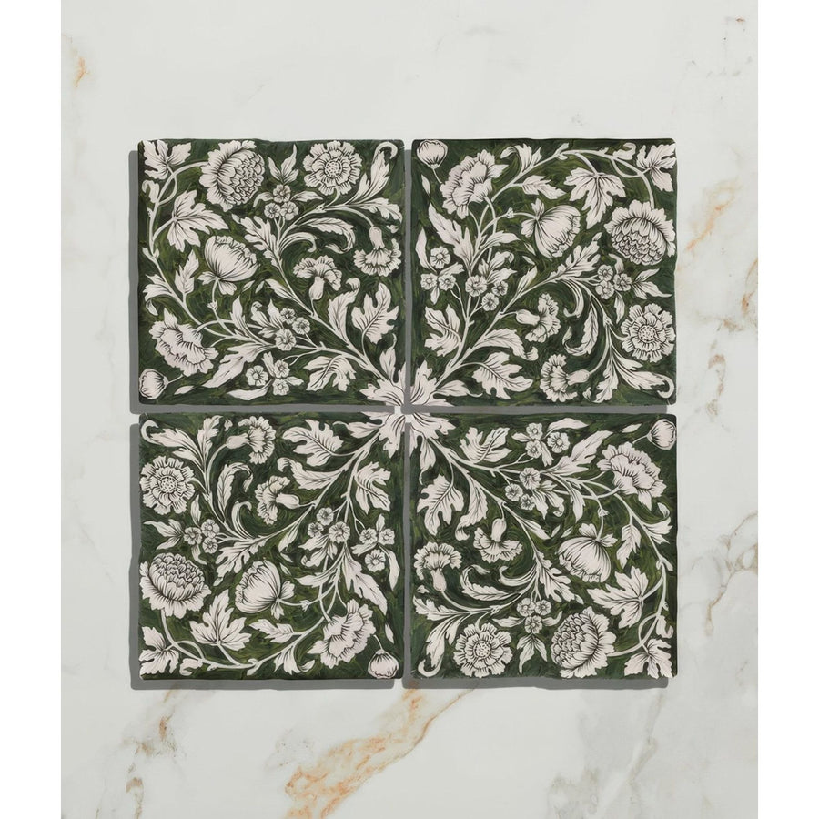 Four square dark green studio assisi ceramic tiles with intricate white floral and vine patterns for decorative use