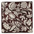 A square studio assisi red ceramic tile with burgundy glaze and intricate white william morris floral pattern