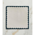 Cream-colored ceramic square plate with dark teal scalloped edge from Studio Bobbin Ceramic Blue collection