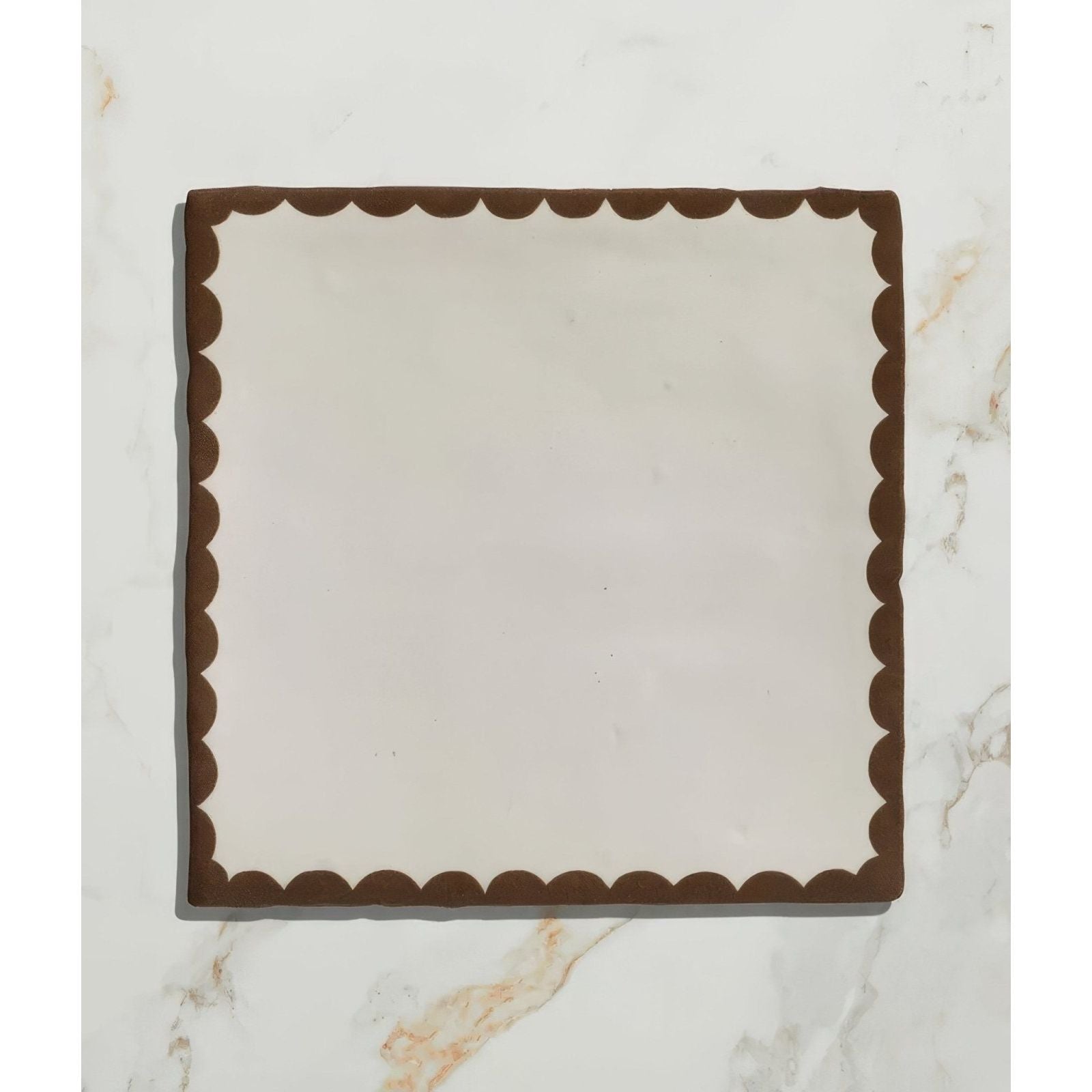 Square ceramic plate by Studio Bobbin with cream center and dark brown scalloped border for serving chocolate