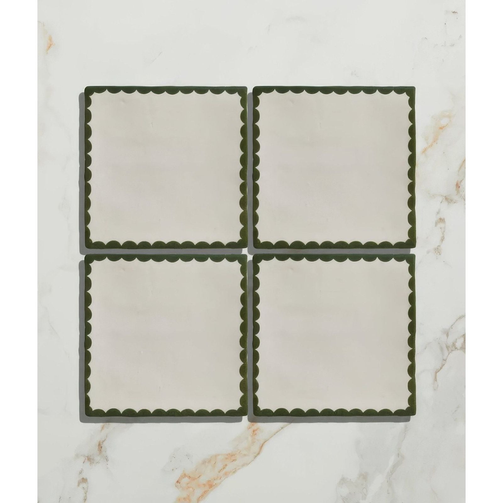 Set of four cream ceramic coasters with dark green scalloped edges from Studio Bobbin ceramic holly collection