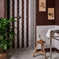 A rustic wooden stool with a round natural-finish seat and three sturdy legs for studio jamboree handpainted ceramic chocolate tri