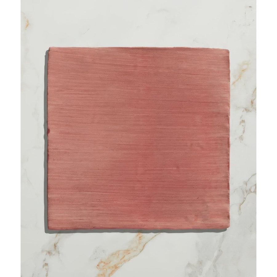 A square terracotta-colored handpainted ceramic tile with subtle horizontal texture from studio jamboree coral field
