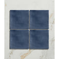 Studio jamboree handpainted ceramic denim field features four navy blue ceramic tiles with a brushed texture arranged in a grid