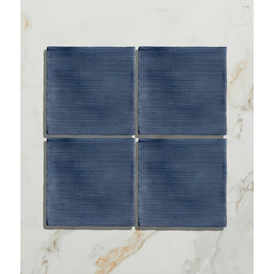 Studio jamboree handpainted ceramic denim field features four navy blue ceramic tiles with a brushed texture arranged in a grid