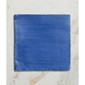 A square ceramic tile from Studio Jamboree handpainted in vibrant cobalt blue with horizontal brushstroke texture