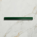 A dark green sleek plastic straw with glossy finish and ridges featured with studio jamboree handpainted ceramic holly beading