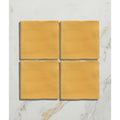 Four square mustard yellow handpainted ceramic tiles from studio jamboree summer field collection arranged in a grid