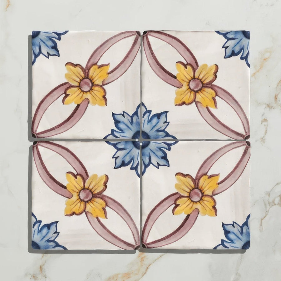 Four-square ceramic tile set with hand-painted yellow, blue, and muted pink floral design by Studio Nonna’s Kitchen Cornelia Ceramic