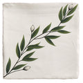 A cream-colored linen pillow sham with hand-painted green leaves and buds along the edge by studio nonna kitchen floreale ceramic