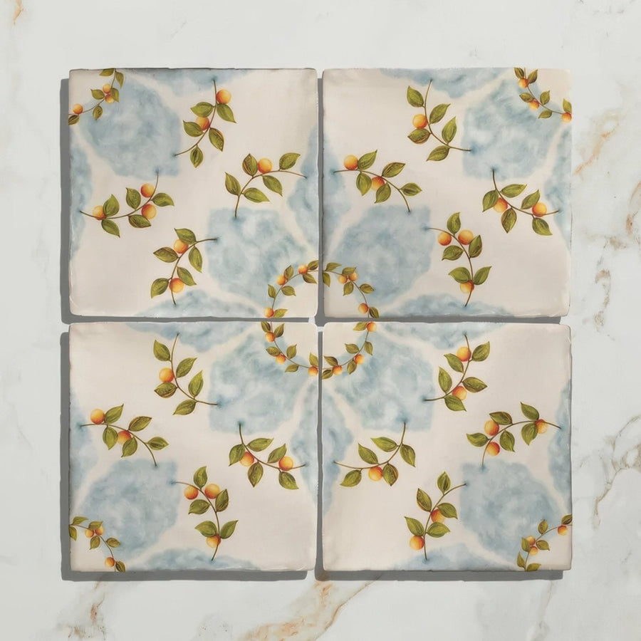 Four square ceramic tiles from Studio Nonna’s kitchen Nuvola Arancio with hand-painted green leaves and orange fruits