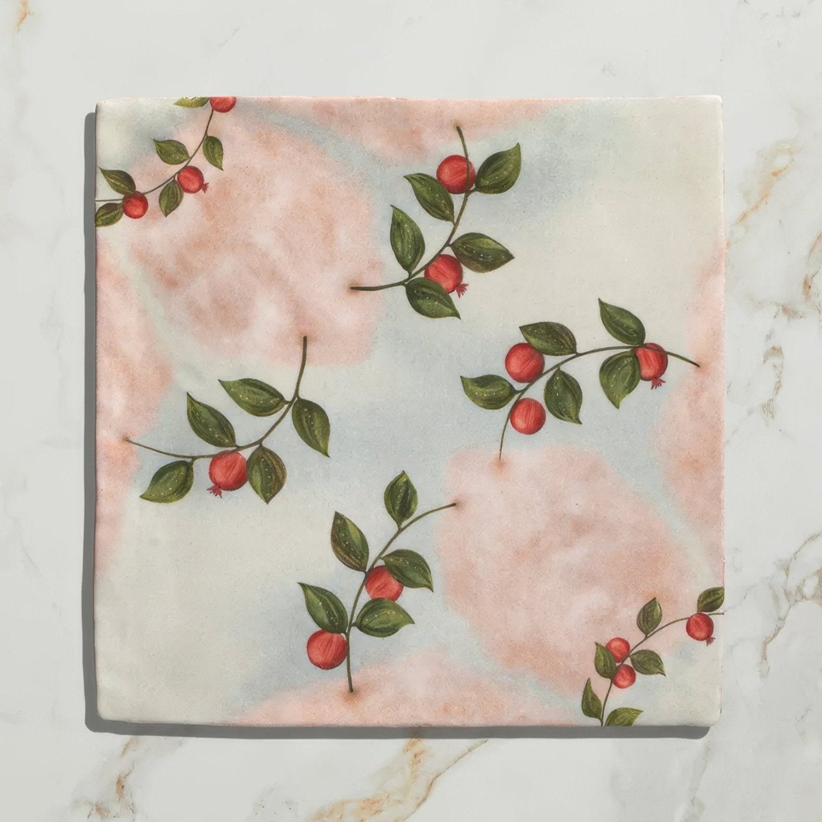 A soft pink and white fabric napkin with green leaves and red berries botanical print for studio nonna kitchen nuvola melograno ceramic