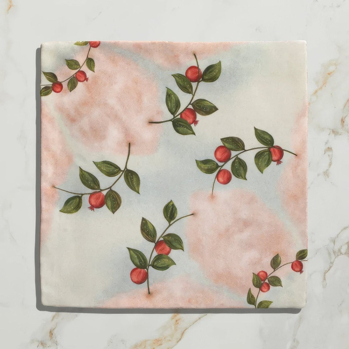 A soft pink and white fabric napkin with green leaves and red berries botanical print for studio nonna kitchen nuvola melograno ceramic