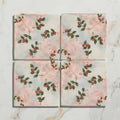 Four square ceramic tiles from studio nonnas kitchen nuvola melograno with hand-painted red berries and green leaves on soft pink and off-white background