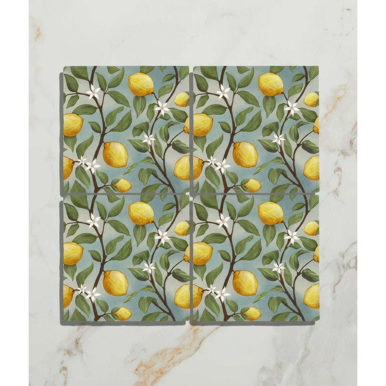 Set of four Studio Nonna ceramic coasters with vibrant lemon tree design on soft blue background for kitchen use